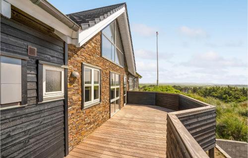 a wooden walkway next to a brick house with a window at Stunning Home In Harboøre With Sauna in Harboør