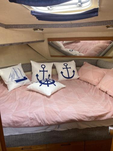 a bed with pillows on top of a boat at Luxury boat in Chertsey