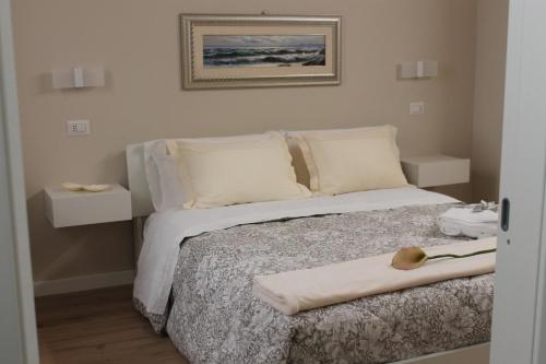 een bed met witte lakens en kussens en een handdoek erop bij Room 369 in Termoli