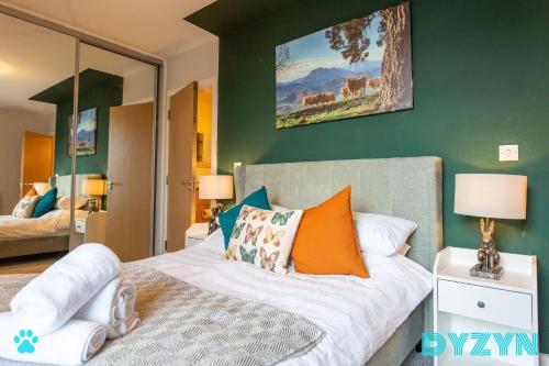 1 dormitorio con 1 cama con almohadas de color naranja en The Lodge - DYZYN Living - GYM - Pool - Balcony - Parking - Cardiff Bay, en Cardiff