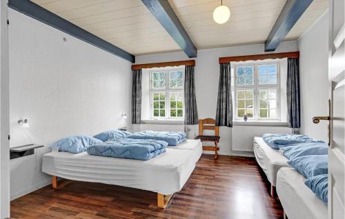 a room with four beds with blue pillows on them at Stunning Home In Hjer With 6 Bedrooms, Sauna And Wifi in Vrågård
