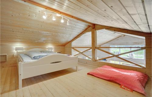エーベルトフトにあるAmazing Home In Ebeltoft With 3 Bedrooms And Wifiの木製の部屋に白いベッドが備わるベッドルーム1室