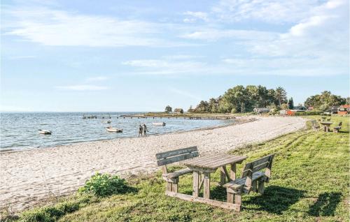 a picnic table and benches on the beach at Stunning Home In Rønde With Kitchen in Rønde