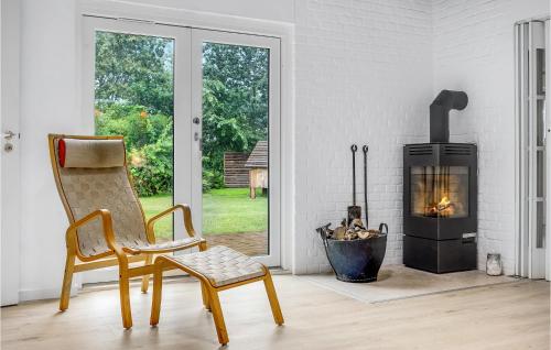 a living room with a chair and a fireplace at 4 Bedroom Lovely Home In Knebel in Knebel