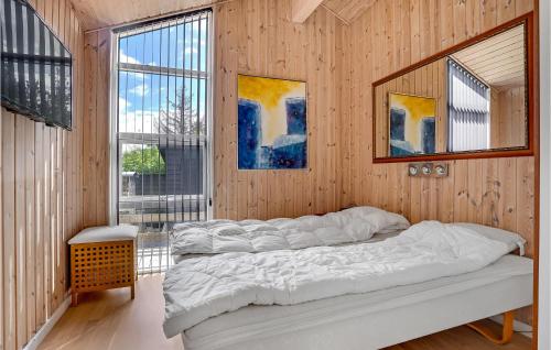 エーベルトフトにあるNice Home In Ebeltoft With Kitchenの木製の壁のベッドルーム1室(ベッド3台付)