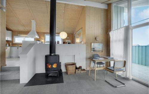 a fireplace in a living room with a desk and a table at Holiday Home Kløvborgsti Thisted Ix in Klitmøller