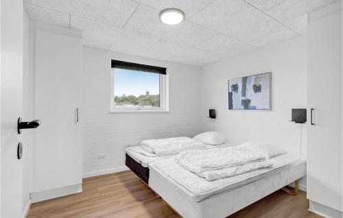 a white room with a bed and a window at 4 Bedroom Awesome Home In Ringkøbing in Ringkøbing