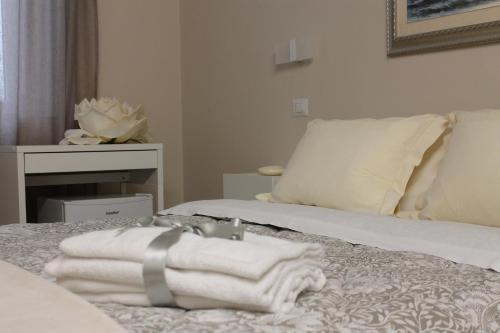 een stapel handdoeken bovenop een bed bij Room 369 in Termoli