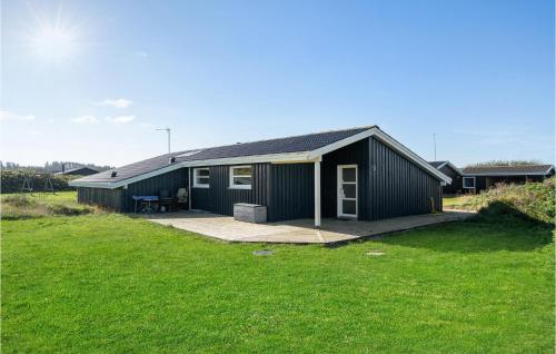 a small black building with a grass yard at Three-Bedroom Holiday Home In Hjorring in Hjørring