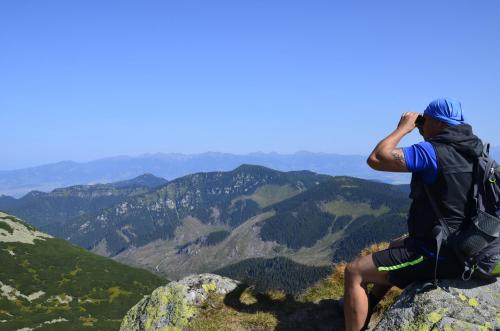 a man sitting on top of a mountain taking a picture at Penzion Larion in Kráľová Lehota