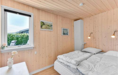 SønderbyにあるNice Home In Juelsminde With 3 Bedrooms And Wifiのベッドルーム(ベッド1台、窓付)