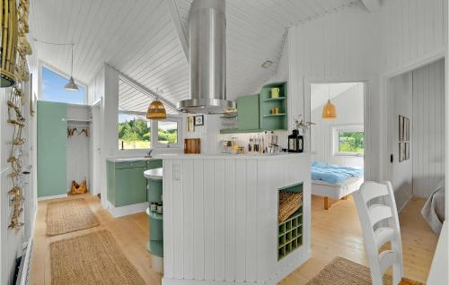 3 Bedroom Lovely Home In ster Assels في Sillerslev: مطبخ مع دواليب خضراء وبيضاء ومغسلة