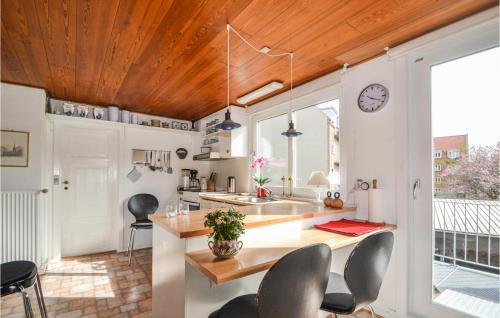 a kitchen with a table and chairs and a clock at Holiday Home Mariagervej in Randers