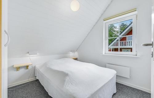 een witte slaapkamer met een bed en een raam bij Marina Fiskens Feriepark in Gråsten