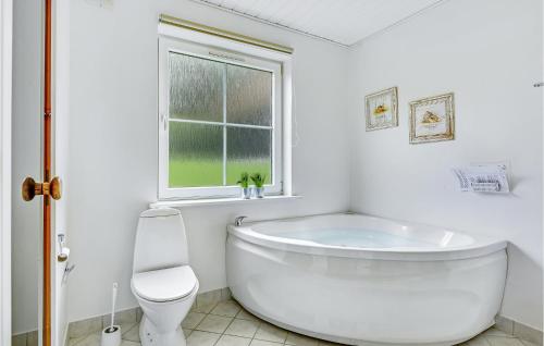 een witte badkamer met een bad en een toilet bij Marina Fiskens Feriepark in Gråsten