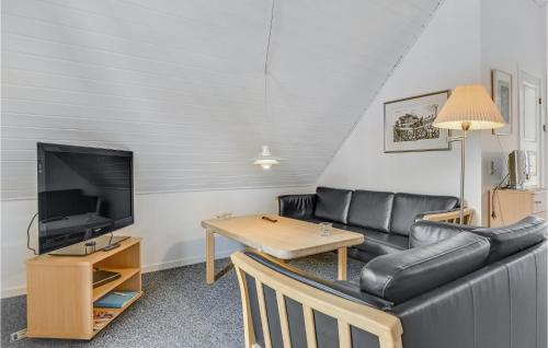 a living room with a couch and a tv and a table at Marina Fiskenæs Feriepark in Gråsten