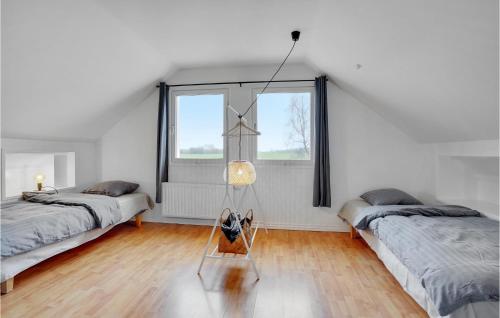 a room with two beds and a glass table at Beautiful Home In Sønder Stenderup in Sønder Stenderup