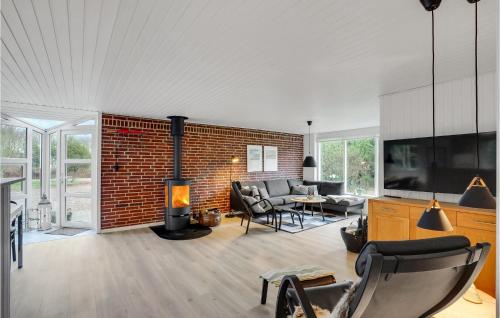 a living room with a fireplace and a brick wall at Beautiful Home In Ringkøbing With Wifi in Ringkøbing