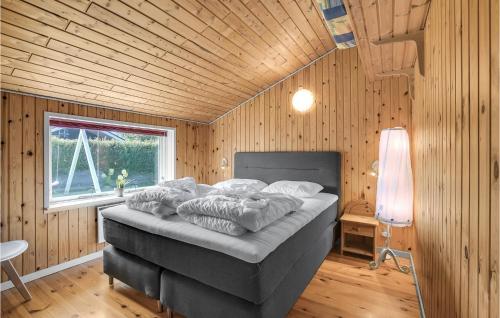 EgernsundにあるBeautiful Home In Egernsund With 2 Bedrooms, Sauna And Wifiの木製の部屋にベッド1台が備わるベッドルーム1室があります。