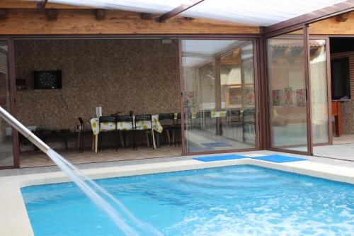 ein Swimmingpool in einem Haus mit einem Tisch und Fenstern in der Unterkunft Casa Rural Abuela Consuelo Estudio La Adobera in San Pascual
