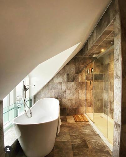 a bathroom with a white tub and a shower at The Lodge at Muir Estate in Thornhill