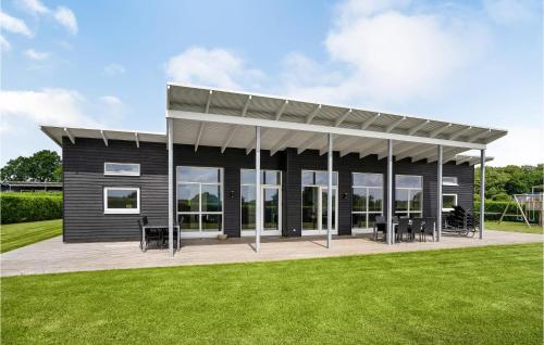 a small black house with awning on a lawn at Holiday Home Podehaven Haderslev in Haderslev