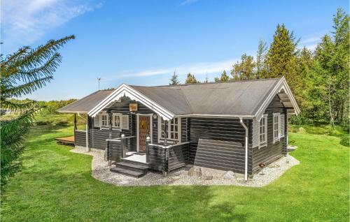 a small cabin with a porch on a green lawn at Holiday Home Venøvej Højslev Denm in Bøstrup