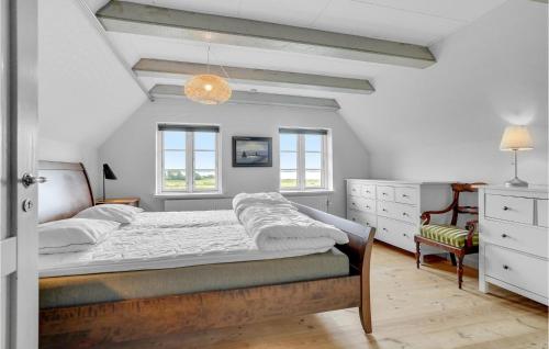 a bedroom with a bed and two windows at Herligheden in Aabenraa