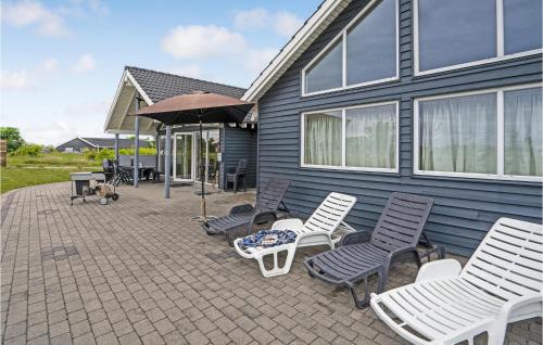 a patio with chairs and a table and an umbrella at 5 Bedroom Beautiful Home In Sydals in Høruphav