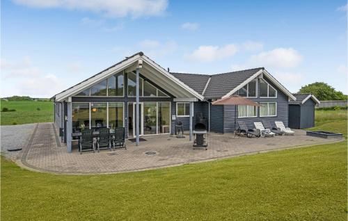 a house with a patio and a grill at 5 Bedroom Beautiful Home In Sydals in Høruphav