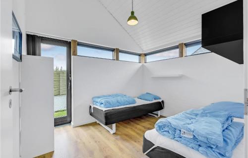 FlovtにあるBeautiful Home In Haderslev With Saunaのベッドルーム1室(ベッド2台、テレビ、窓付)