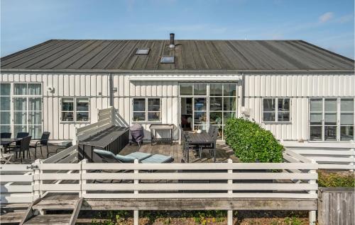 a white house with chairs and tables in front of it at Hummeren 116 in Ebeltoft