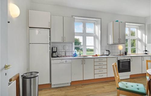 a kitchen with white appliances and a table and chairs at 6 Bedroom Gorgeous Home In Kværndrup in Kværndrup