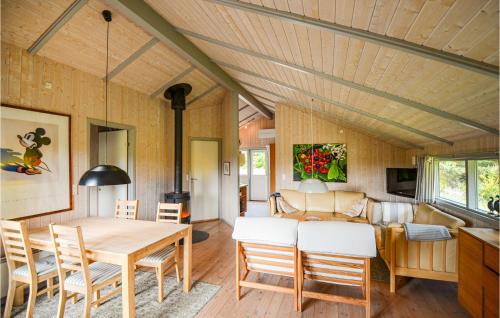a dining room and living room with a table and chairs at Holiday Home Gl Kirkebjerg Knebel Ii in Knebel
