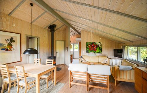 KnebelにあるStunning Home In Knebel With 3 Bedrooms, Sauna And Wifiのダイニングルーム、リビングルーム(テーブル、椅子付)