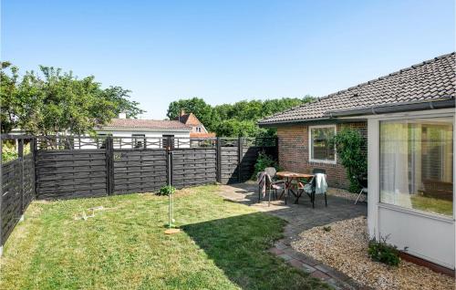 a backyard with a fence and a table and chairs at Gorgeous Home In Millinge With Wifi in Millinge