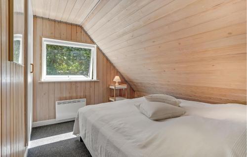 a bedroom with a bed in a wooden room at Awesome Home In Asperup With Sauna, Wifi And Indoor Swimming Pool in Asperup