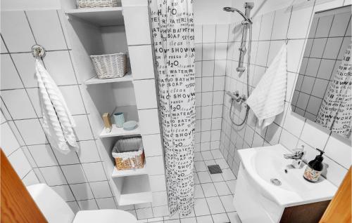biała łazienka z prysznicem i umywalką w obiekcie Mormors Hus w mieście Mariager