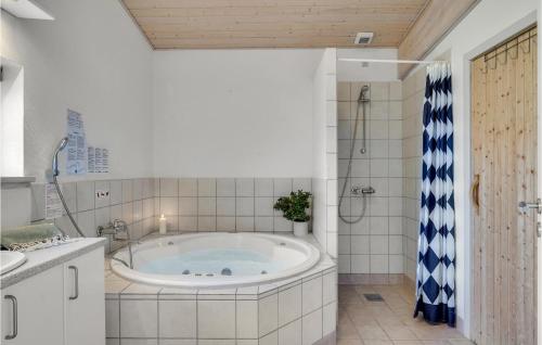 a bathroom with a tub and a shower at Beautiful Home In Faaborg With Sauna in Nabbe