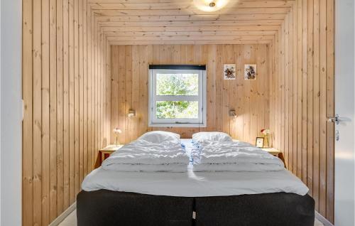 Øster Hurupにある4 Bedroom Amazing Home In Hadsundの木製の壁に大きなベッドが備わるベッドルーム1室