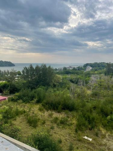 a view of a field with the ocean in the background at Private Condo Port Dickson Waterfront in Port Dickson