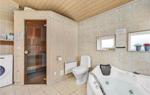 uma casa de banho com uma banheira, um WC e um lavatório. em Beautiful Home In Juelsminde With 3 Bedrooms, Sauna And Wifi em Sønderby