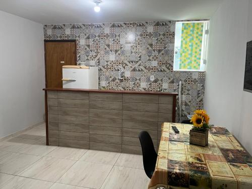 cocina con encimera y mesa con nevera en Suite para temporada en Arraial do Cabo