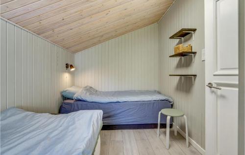 een kleine kamer met 2 bedden en een kruk bij Stunning Home In Storvorde With Wifi in Storvorde