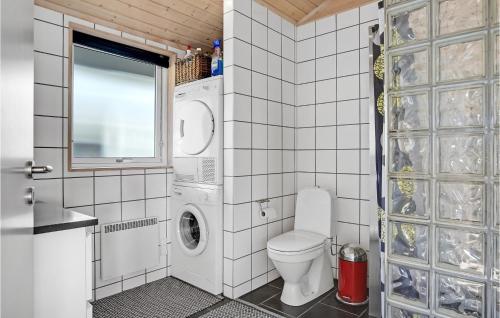 La salle de bains est pourvue de toilettes et d'un lave-linge. dans l'établissement 3 Bedroom Amazing Home In Rnde, à Rønde