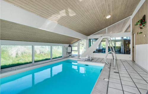 a swimming pool with a slide in a house at Awesome Home In Blokhus With Wifi in Blokhus