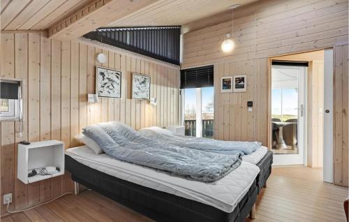 - une chambre avec un grand lit et des murs en bois dans l'établissement 3 Bedroom Amazing Home In Rnde, à Rønde
