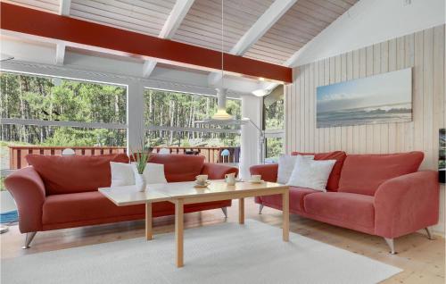 a living room with red couches and a table at Godt Gemt in Vester Sømarken