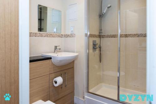 a bathroom with a shower and a sink and a shower at The Lodge - DYZYN Living - GYM - Pool - Balcony - Parking - Cardiff Bay in Cardiff