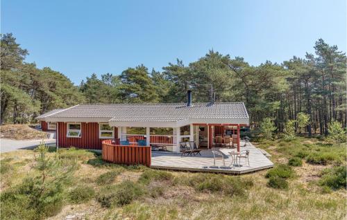 a house with a deck in the middle of a field at Godt Gemt in Vester Sømarken